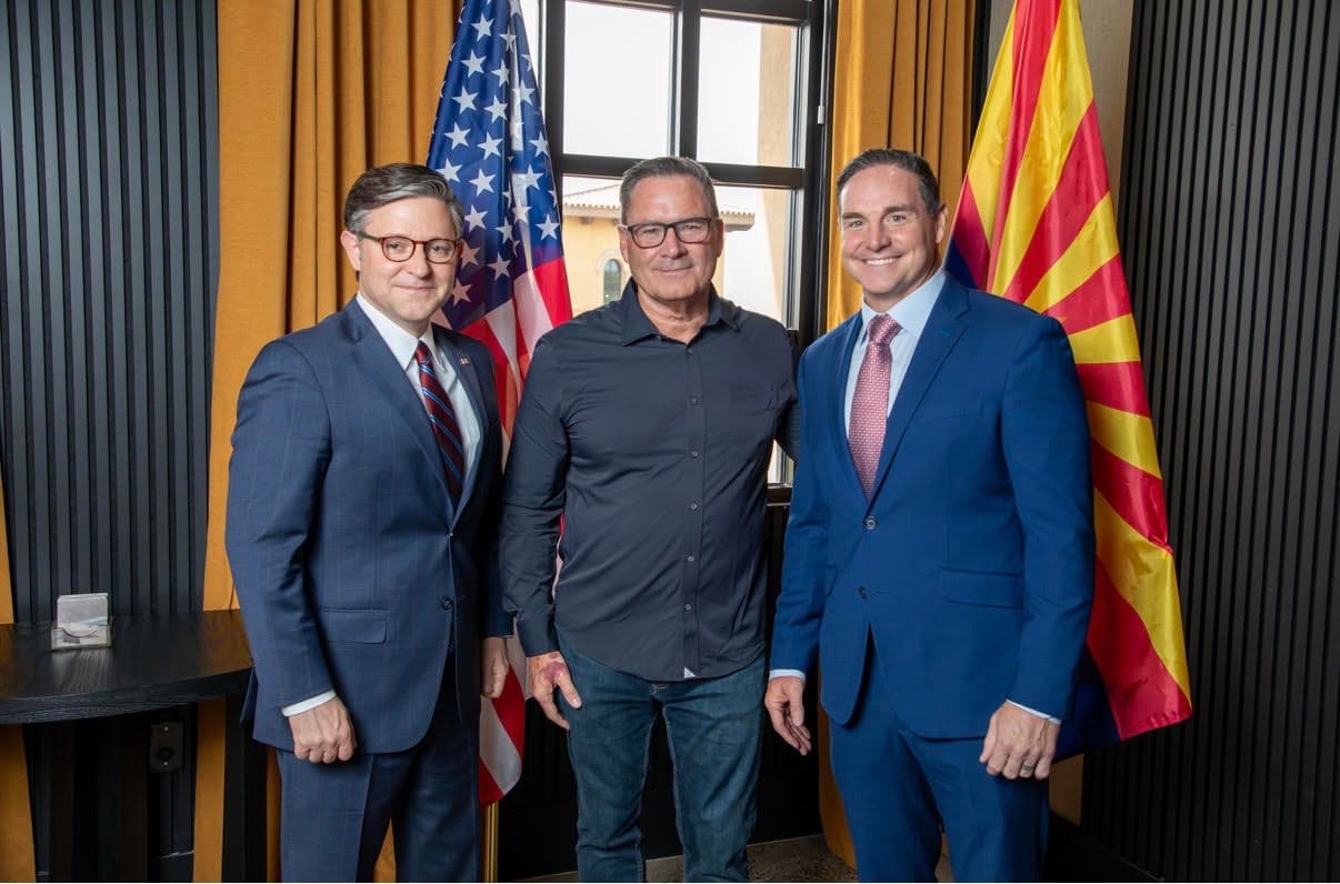 Chuck Warren with elected officials in front of United States and Arizona flags